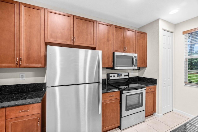 7359 Briella Dr, Boynton Beach, FL 33437 - kitchen with appliances with stainless steel finishes, dark stone counters, baseboards, brown cabinets, and recessed lighting