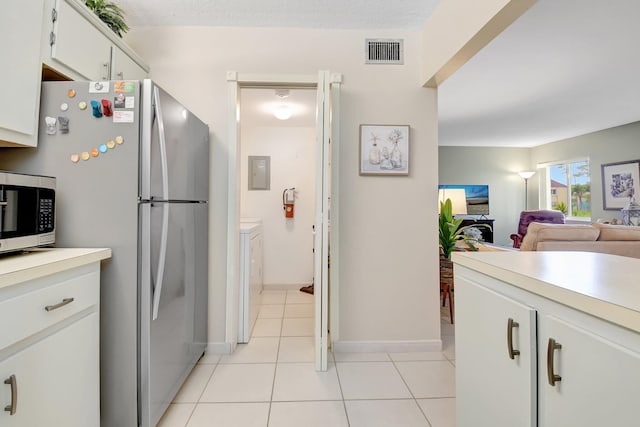 338 Pine Ridge Cir Unit B-1, Greenacres, FL 33463 - kitchen featuring appliances with stainless steel finishes, washer and clothes dryer, light countertops, electric panel, and light tile patterned floors