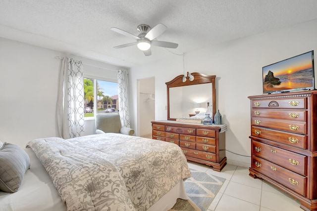 338 Pine Ridge Cir Unit B-1, Greenacres, FL 33463 - bedroom featuring a textured ceiling, ceiling fan, light tile patterned floors, and a walk in closet