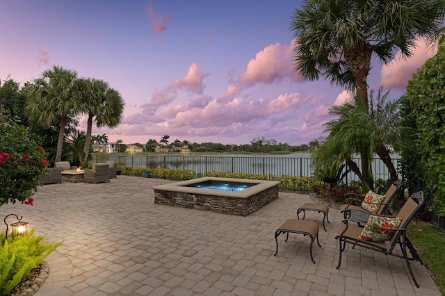 725 Edgebrook Ln, West Palm Beach, FL 33411 - patio terrace at dusk with a water view, a patio, an outdoor hot tub, and an outdoor hangout area