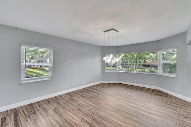 1220 N Swinton Ave, Delray Beach, FL 33444 - spare room featuring wood finished floors, baseboards, and a chandelier