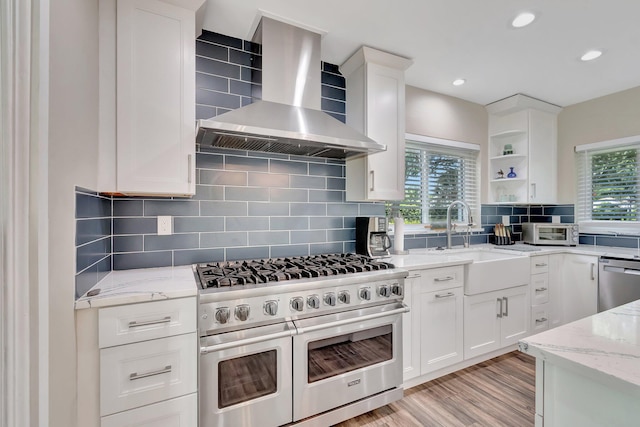 1220 N Swinton Ave, Delray Beach, FL 33444 - kitchen featuring stainless steel appliances, wall chimney exhaust hood, healthy amount of natural light, a sink, and recessed lighting