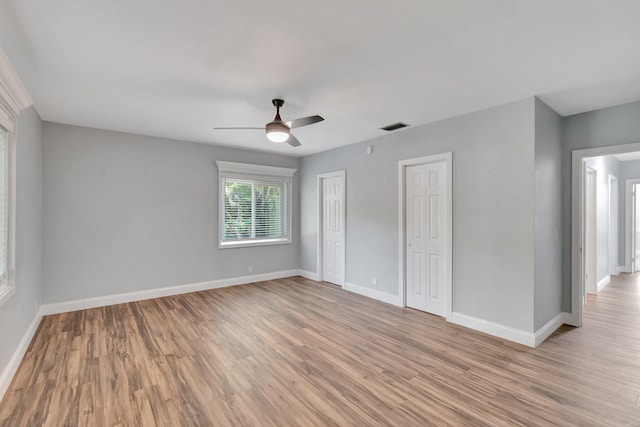1220 N Swinton Ave, Delray Beach, FL 33444 - unfurnished bedroom with two closets, light wood finished floors, and baseboards