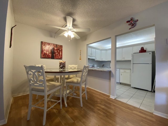 302 Pine Ridge Cir Unit D-1, Greenacres, FL 33463 - dining area featuring light wood finished floors, a textured ceiling, ceiling fan, and baseboards