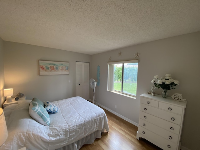 302 Pine Ridge Cir Unit D-1, Greenacres, FL 33463 - bedroom featuring wood finished floors, a textured ceiling, baseboards, and a closet