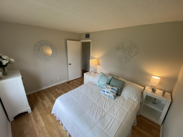 302 Pine Ridge Cir Unit D-1, Greenacres, FL 33463 - bedroom featuring light wood finished floors, a textured ceiling, and baseboards