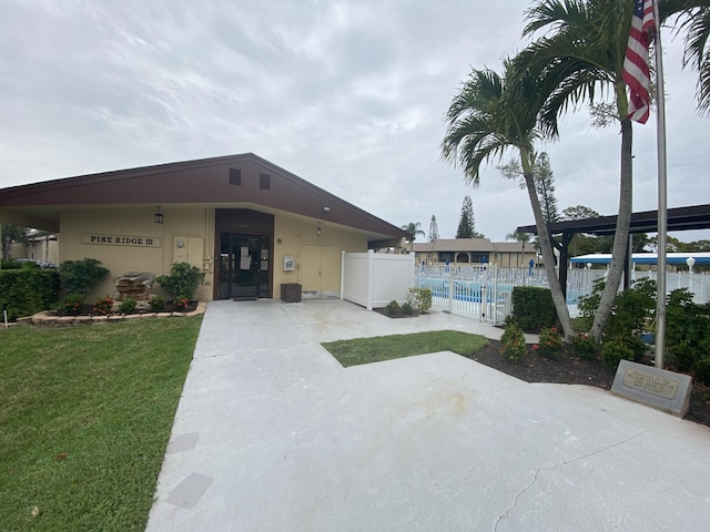 302 Pine Ridge Cir Unit D-1, Greenacres, FL 33463 - view of front facade featuring a swimming pool and a patio area