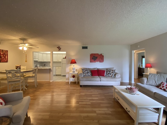 302 Pine Ridge Cir Unit D-1, Greenacres, FL 33463 - living area featuring a textured ceiling, light wood-type flooring, and ceiling fan