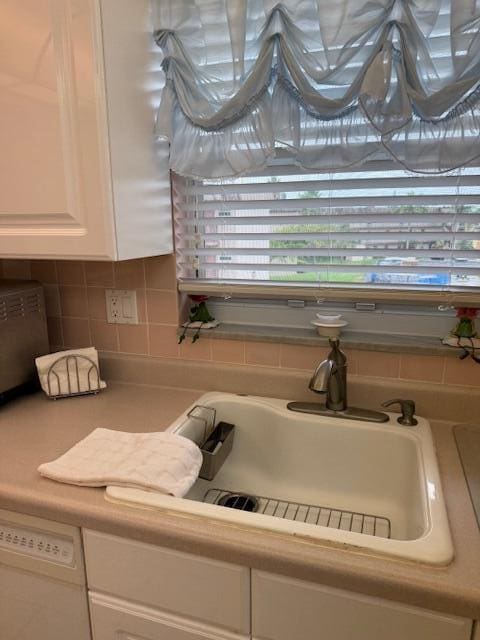 725 Lori Dr Unit 313, Palm Springs, FL 33461 - kitchen view of white cabinets, light countertops, backsplash, and white dishwasher