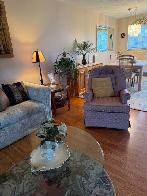 725 Lori Dr Unit 313, Palm Springs, FL 33461 - living area featuring a chandelier, wood finished floors, and a textured ceiling