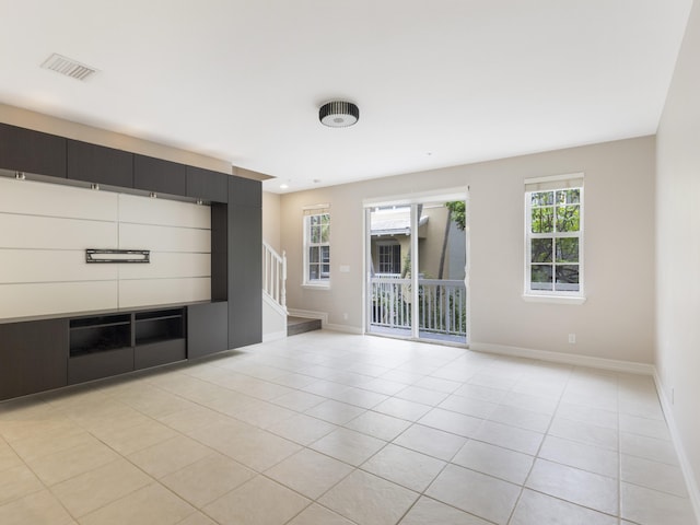 110 W Coda Cir Unit 110, Delray Beach, FL 33444 - unfurnished living room with light tile patterned flooring, stairway, and baseboards