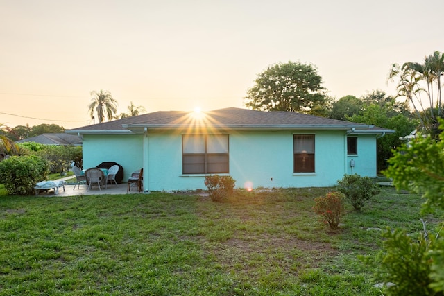 2511 SE Marius St, Port Saint Lucie, FL 34953 - back of property featuring stucco siding, a patio area, and a lawn