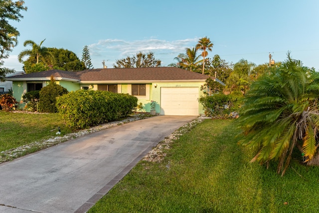 2511 SE Marius St, Port Saint Lucie, FL 34953 - ranch-style house with concrete driveway, stucco siding, an attached garage, and a front yard