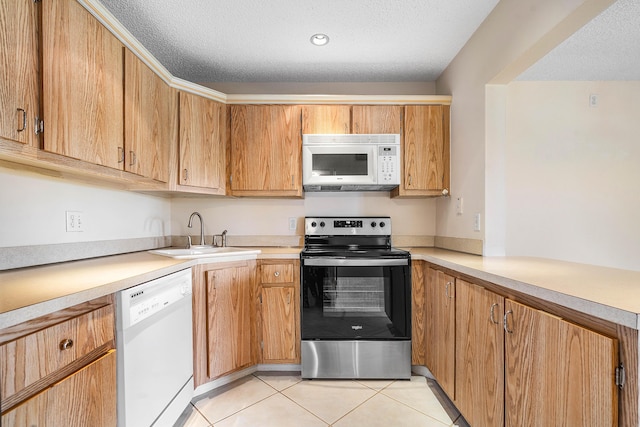521 Shady Pine Way Unit C2, Greenacres, FL 33415 - kitchen featuring white appliances, a sink, light countertops, a textured ceiling, and light tile patterned flooring