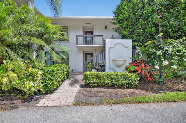 3946 Quail Ridge Dr N, Boynton Beach, FL 33436 - view of property featuring stairway, stucco siding, and a balcony