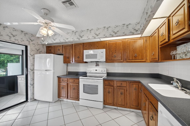 3946 Quail Ridge Dr N, Boynton Beach, FL 33436 - kitchen featuring white appliances, a sink, brown cabinets, dark countertops, and wallpapered walls
