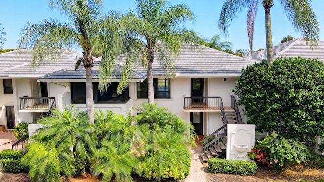 3946 Quail Ridge Dr N, Boynton Beach, FL 33436 - rear view of property featuring stairway and stucco siding