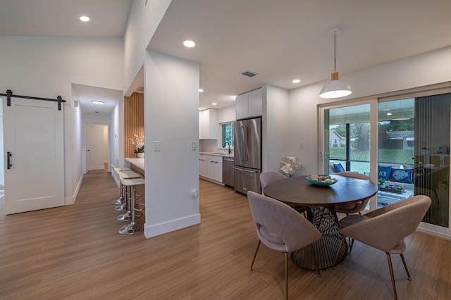18085 102nd Way S, Boca Raton, FL 33498 - dining space featuring a barn door, light wood-style flooring, and recessed lighting
