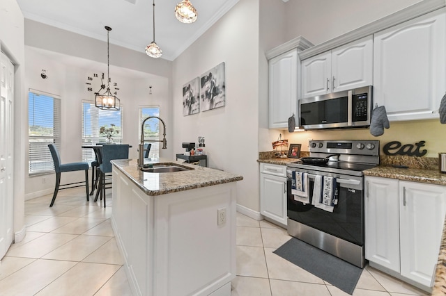 2450 SW Summit St, Port Saint Lucie, FL 34984 - kitchen with stainless steel appliances, a sink, crown molding, light tile patterned floors, and a center island with sink