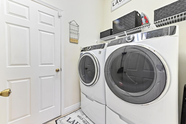 2450 SW Summit St, Port Saint Lucie, FL 34984 - laundry room featuring washing machine and dryer and baseboards