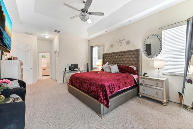 2450 SW Summit St, Port Saint Lucie, FL 34984 - bedroom featuring a raised ceiling, multiple windows, light colored carpet, and connected bathroom