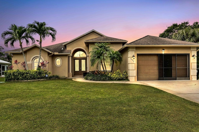 2450 SW Summit St, Port Saint Lucie, FL 34984 - view of front of home with french doors, stucco siding, driveway, a front lawn, and an attached garage