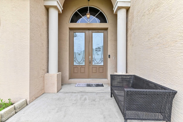 2450 SW Summit St, Port Saint Lucie, FL 34984 - doorway to property featuring stucco siding and french doors