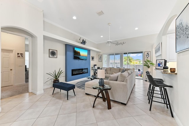 2450 SW Summit St, Port Saint Lucie, FL 34984 - living room with a ceiling fan, a glass covered fireplace, recessed lighting, light tile patterned flooring, and arched walkways