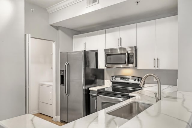 4903 Midtown Ln Unit 3114, Palm Beach Gardens, FL 33418 - kitchen featuring stainless steel appliances, light stone counters, white cabinetry, and light wood-style floors