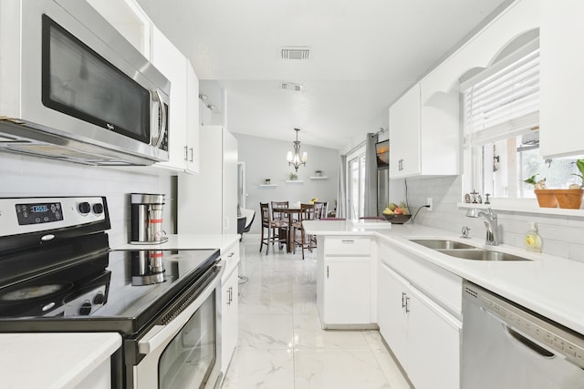 1913 SW Idaho Ln, Port Saint Lucie, FL 34953 - kitchen featuring stainless steel appliances, a sink, light marble finish flooring, white cabinetry, and tasteful backsplash
