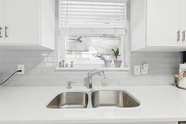 1913 SW Idaho Ln, Port Saint Lucie, FL 34953 - kitchen with a sink, white cabinets, light countertops, and backsplash