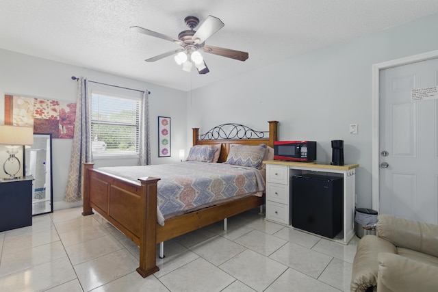 1913 SW Idaho Ln, Port Saint Lucie, FL 34953 - bedroom with fridge, a textured ceiling, light tile patterned floors, and a ceiling fan