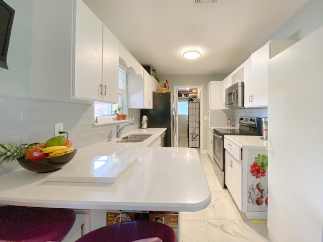 1913 SW Idaho Ln, Port Saint Lucie, FL 34953 - kitchen with stainless steel appliances, a sink, tasteful backsplash, and light countertops