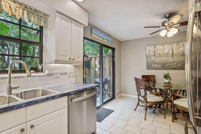 200 S Ocean Blvd Unit B-135, Delray Beach, FL 33483 - kitchen featuring stainless steel dishwasher, a sink, dark countertops, ceiling fan, and white cabinets