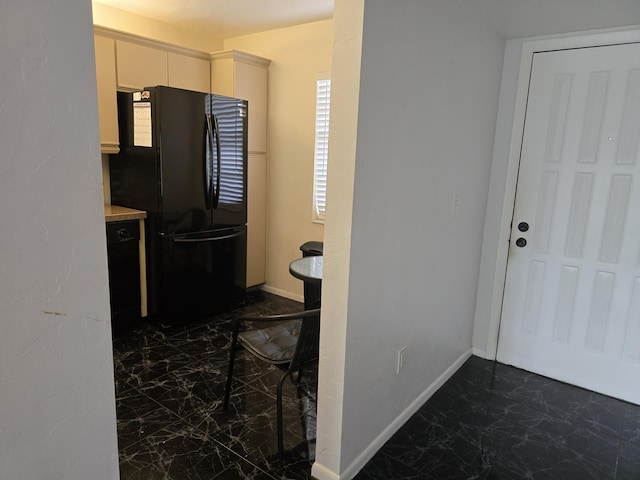 150 Lake Nancy Ln Unit 222, West Palm Beach, FL 33411 - kitchen featuring freestanding refrigerator, dark marble finish flooring, white cabinets, and baseboards
