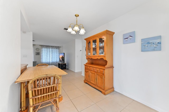 522 Evergreen Dr, Lake Park, FL 33403 - dining area featuring a chandelier, light tile patterned floors, and baseboards