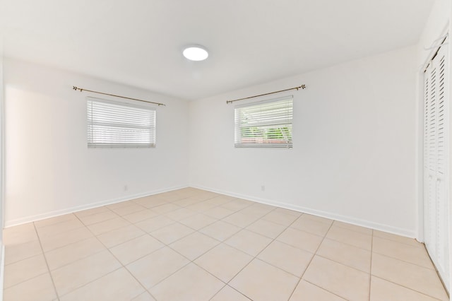 522 Evergreen Dr, Lake Park, FL 33403 - unfurnished bedroom with baseboards, a closet, and light tile patterned floors
