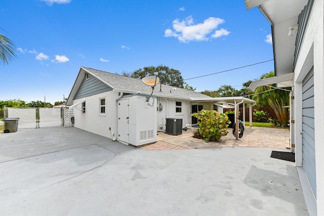 522 Evergreen Dr, Lake Park, FL 33403 - back of house with a patio area, cooling unit, and roof with shingles