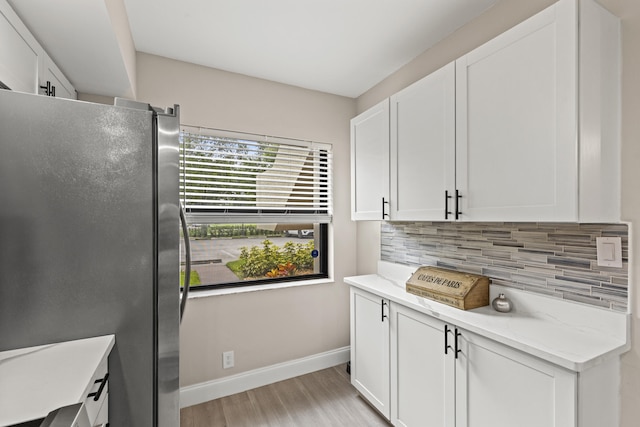 12829 Briarlake Dr Unit 102, Palm Beach Gardens, FL 33418 - kitchen featuring freestanding refrigerator, baseboards, tasteful backsplash, light wood-style flooring, and white cabinetry