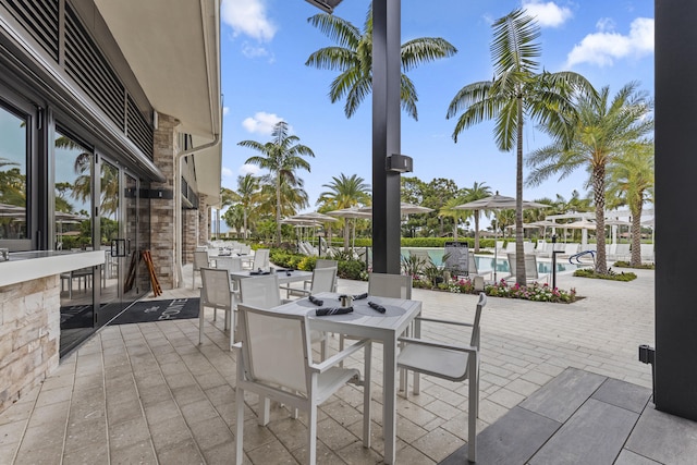 12829 Briarlake Dr Unit 102, Palm Beach Gardens, FL 33418 - view of patio with an outdoor pool, outdoor dining space, and exterior bar