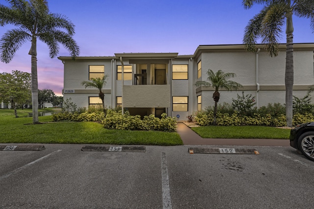12829 Briarlake Dr Unit 102, Palm Beach Gardens, FL 33418 - property at dusk featuring uncovered parking