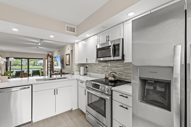 12829 Briarlake Dr Unit 102, Palm Beach Gardens, FL 33418 - kitchen with stainless steel appliances, a sink, recessed lighting, light countertops, and white cabinetry