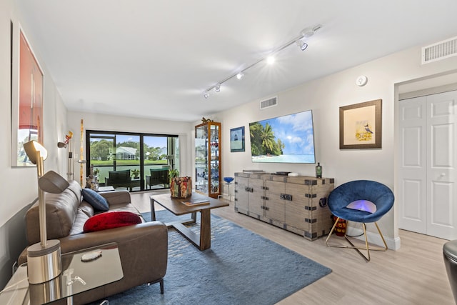 12829 Briarlake Dr Unit 102, Palm Beach Gardens, FL 33418 - living room featuring light wood-type flooring, rail lighting, and baseboards