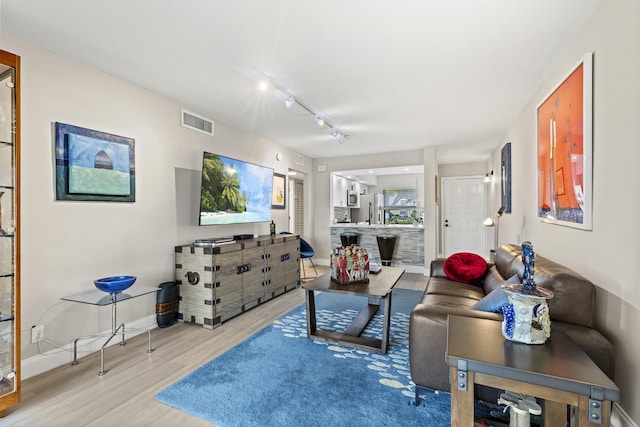 12829 Briarlake Dr Unit 102, Palm Beach Gardens, FL 33418 - living area featuring baseboards, wood finished floors, and rail lighting