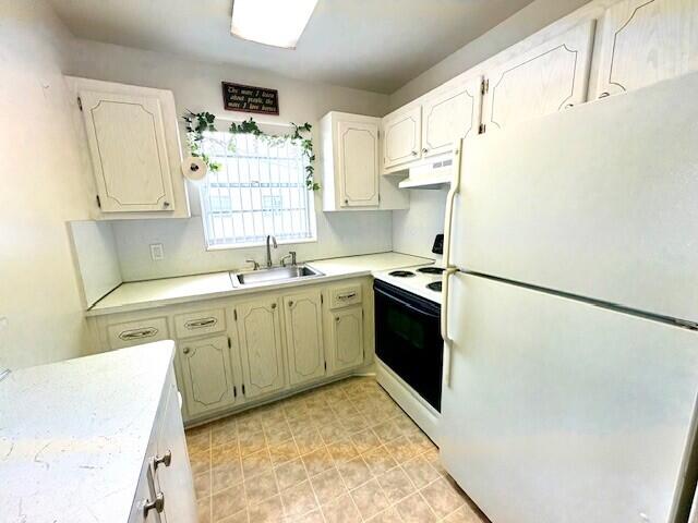 127 Berkshire F, West Palm Beach, FL 33417 - kitchen with white appliances, a sink, under cabinet range hood, and light countertops