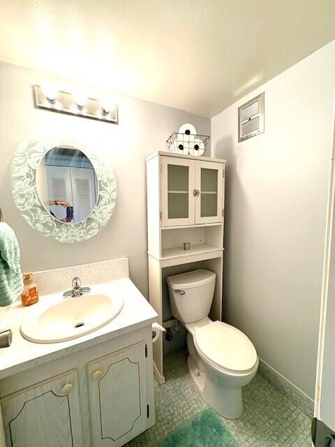 127 Berkshire F, West Palm Beach, FL 33417 - bathroom with toilet, vanity, and baseboards