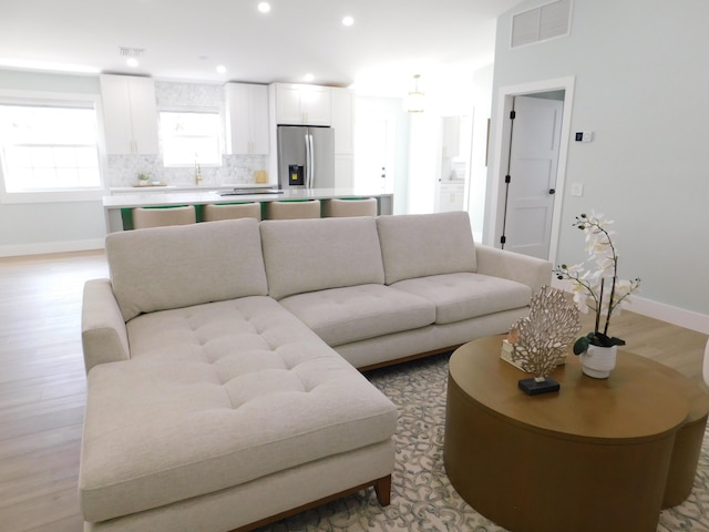 889 SW Balmoral Trce, Stuart, FL 34997 - living room featuring light wood-type flooring, baseboards, and recessed lighting