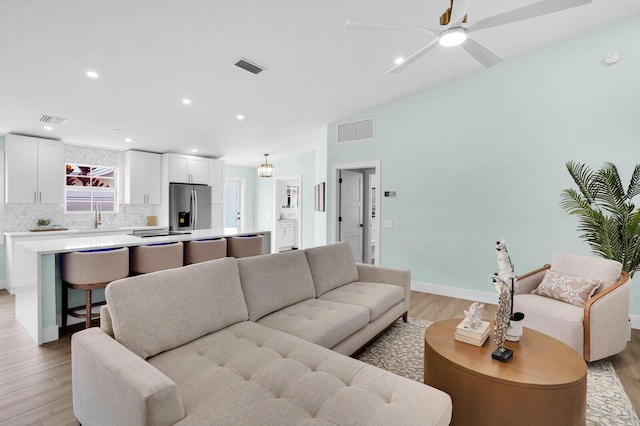 889 SW Balmoral Trce, Stuart, FL 34997 - living area featuring light wood finished floors, vaulted ceiling, and ceiling fan
