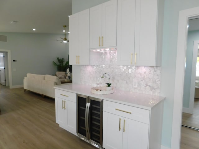 889 SW Balmoral Trce, Stuart, FL 34997 - indoor wet bar featuring beverage cooler, tasteful backsplash, wood finished floors, a ceiling fan, and recessed lighting