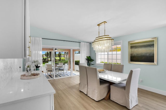 889 SW Balmoral Trce, Stuart, FL 34997 - dining space with light wood finished floors, a chandelier, and lofted ceiling